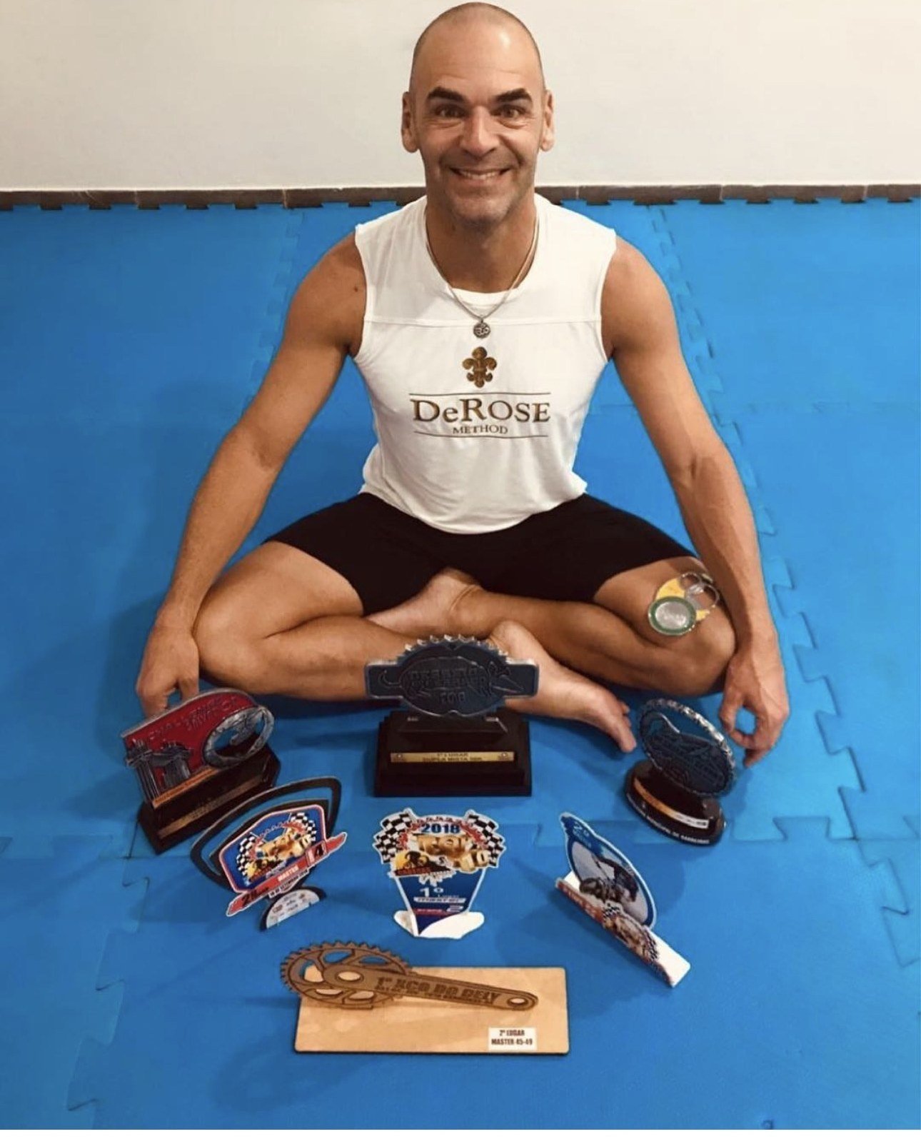 Anderson Oliveira ciclista vestindo regata DeROSE Method com troféus de provas Master